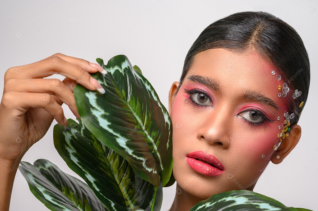 Mulher colocou maquiagem rosa e decorada com folhas. Isolado no fundo branco
