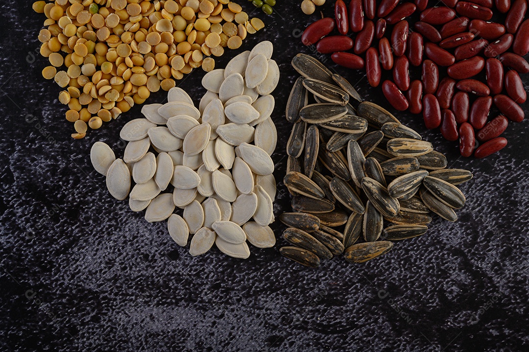 Legumes dispostos em círculo no chão de cimento preto. Vista do topo.