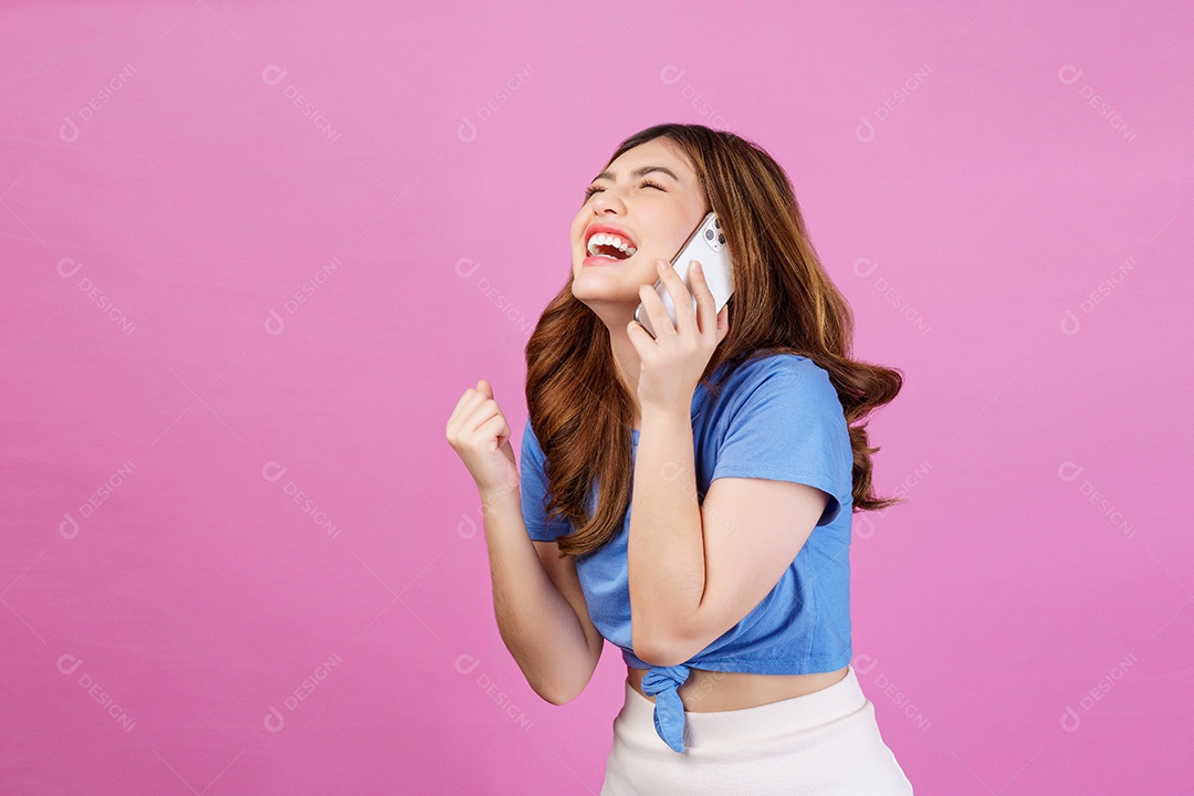 Retrato de jovem feliz vestindo camiseta casual falando no celular isolado sobre fundo rosa. Conceito de tecnologia, pessoas e estilo de vida.