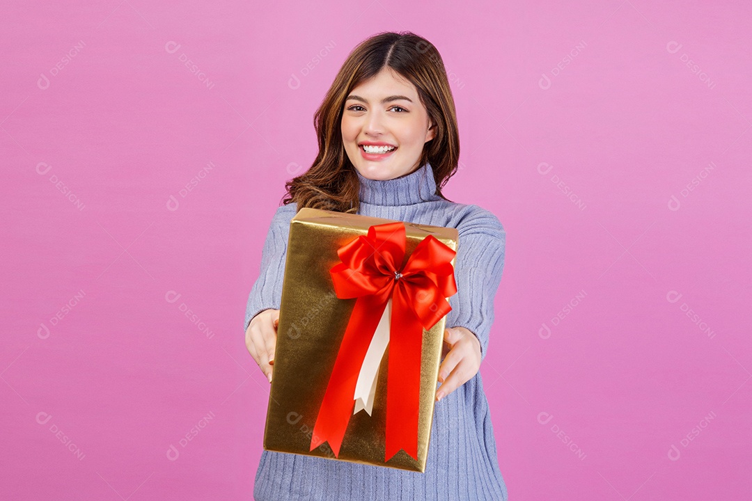 Retrato de jovem surpreso animado segurando o presente nas mãos dela isolado sobre fundo rosa. Conceito de aniversário e celebração.
