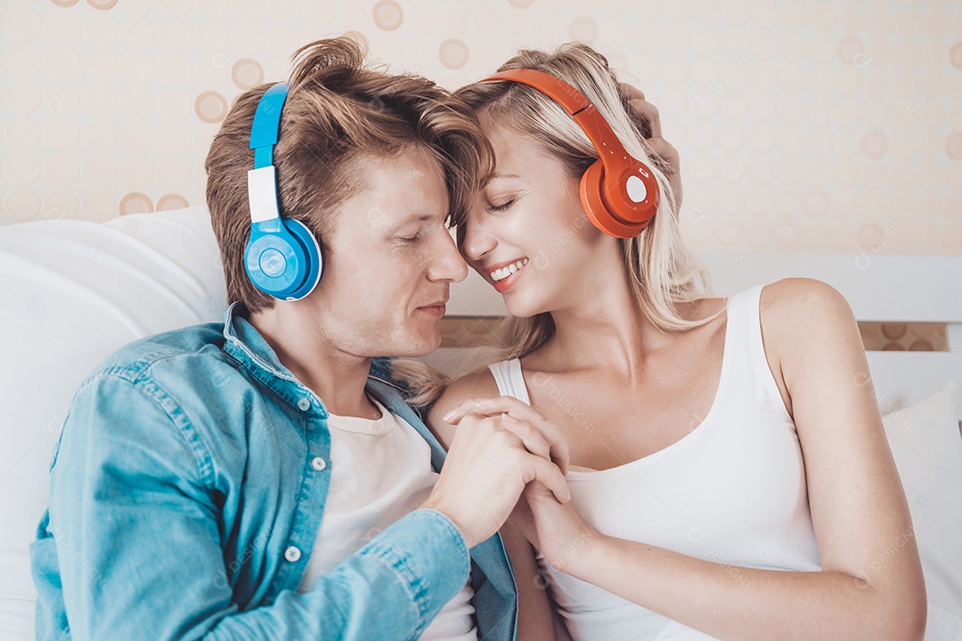 Casal feliz ouvindo música de manhã no quarto