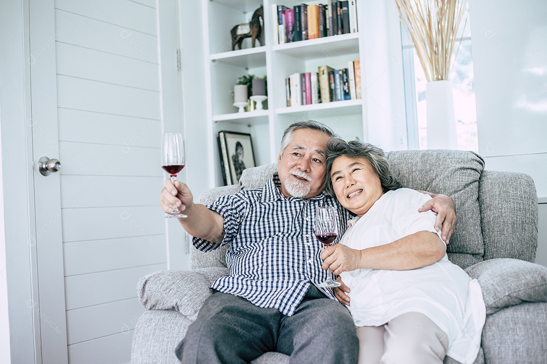 Mulher idosa feliz e seu marido bebendo vinho e felicidade