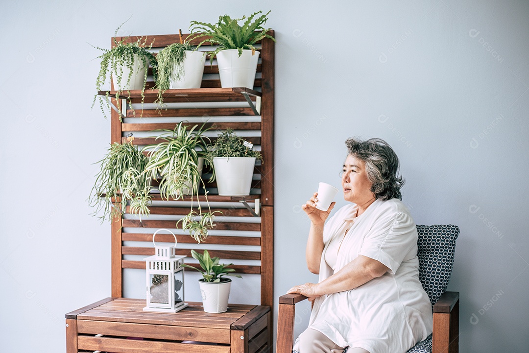 Mulher sênior sentada e bebendo café ou leite