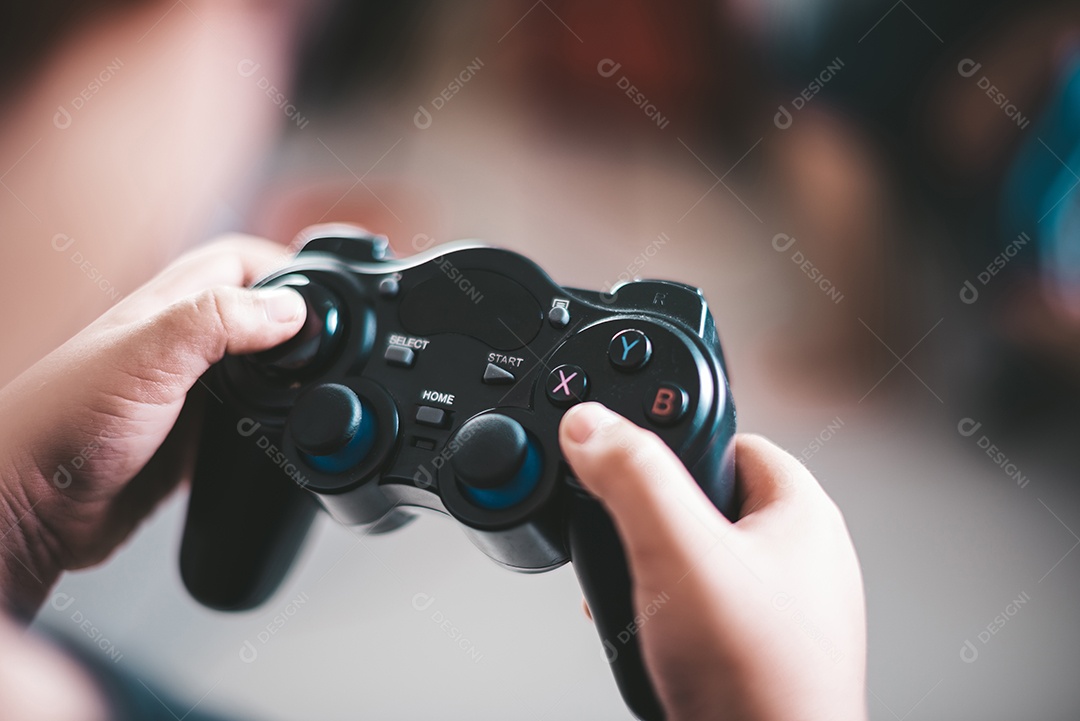Garoto feliz joga computador de jogo com um controlador em foto de estúdio