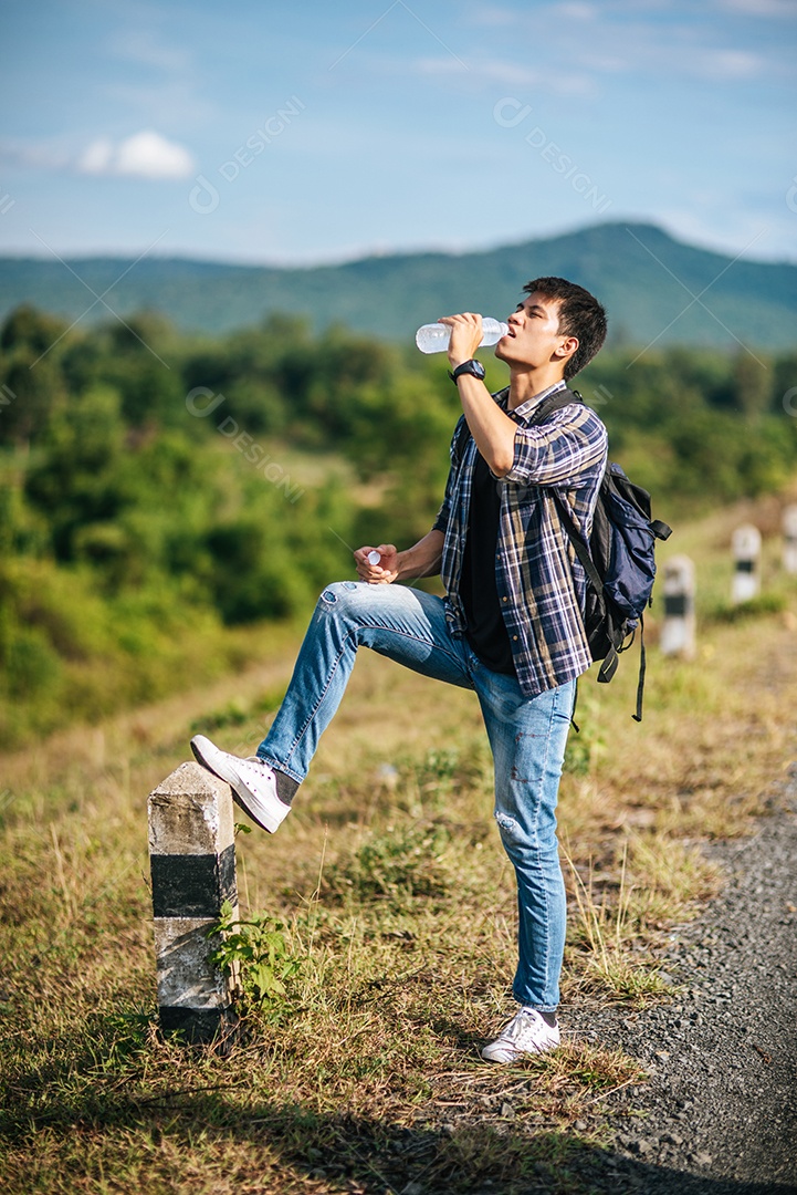 Viajante masculino com uma mochila segurando um mapa e perto de um quilômetro.