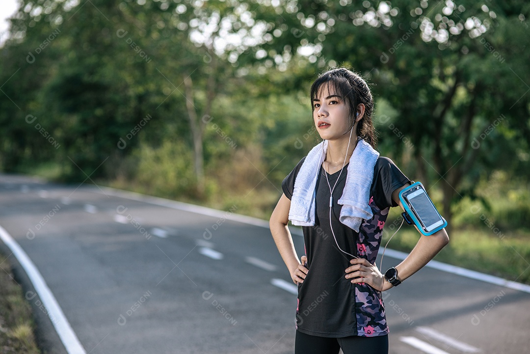 Mulher em pé Relaxe após o exercício na estrada