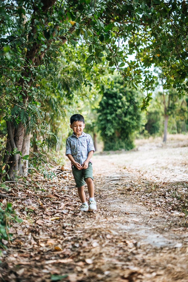 Garoto feliz jogando sozinho no parque