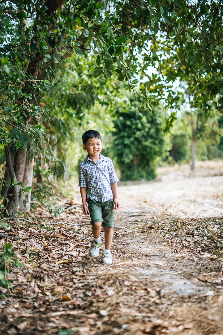 Garoto feliz jogando sozinho no parque