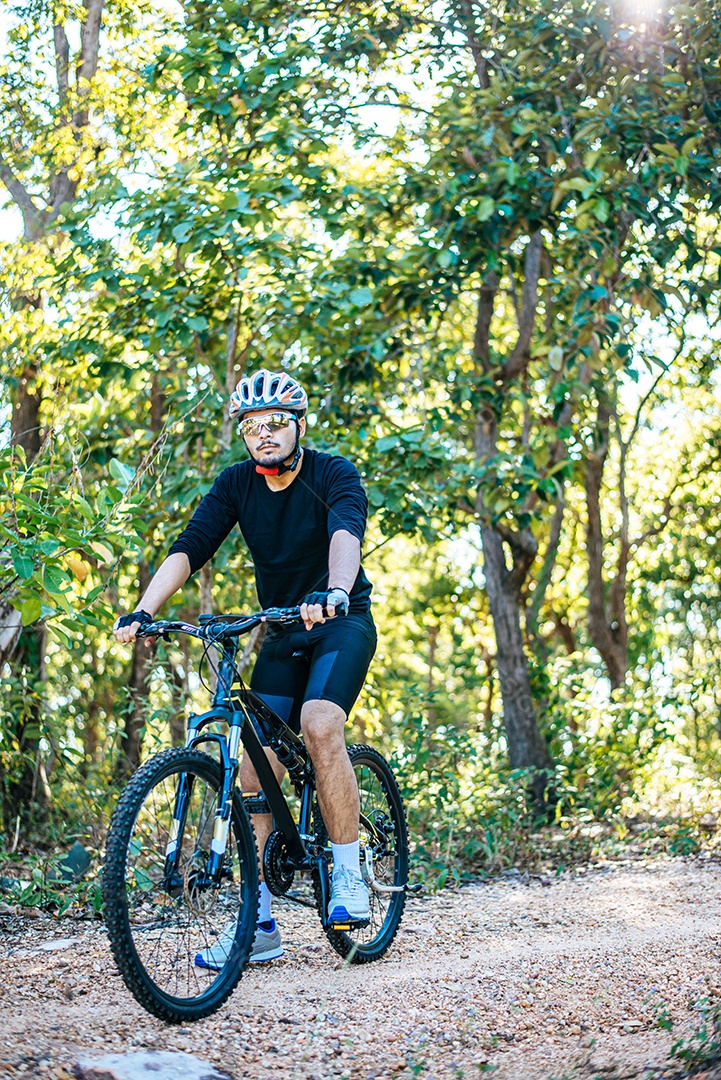 O homem andando de bicicleta em um caminho de montanha.