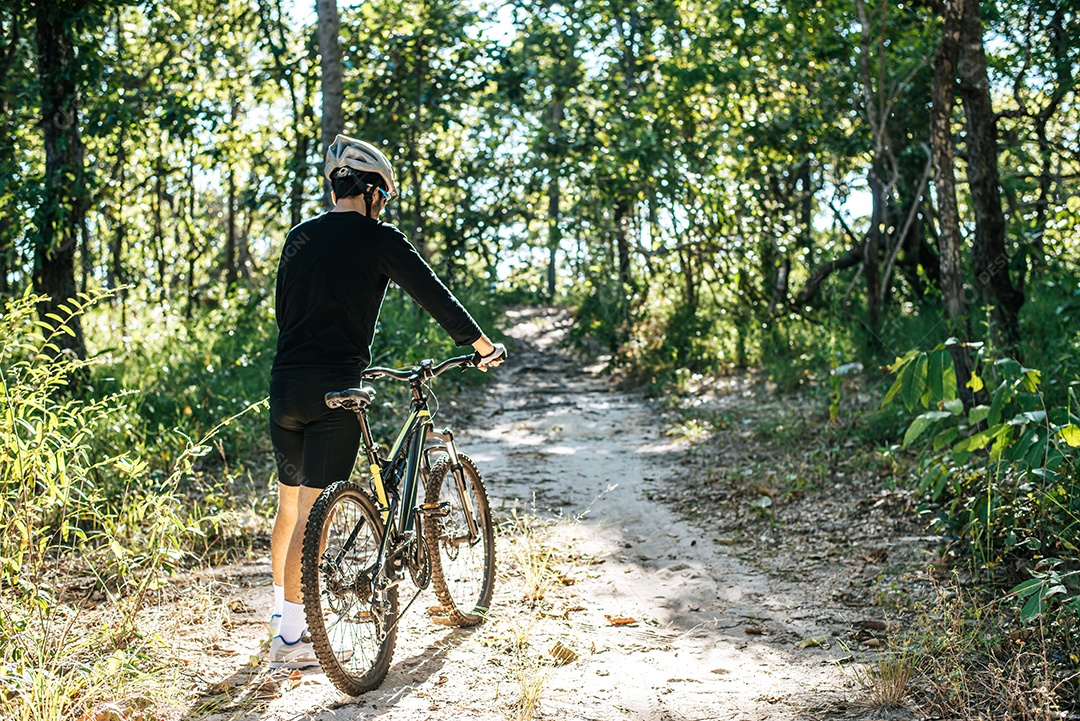 Bicicleta de montanha masculina em pé na estrada ao ar livre na natureza de verão.