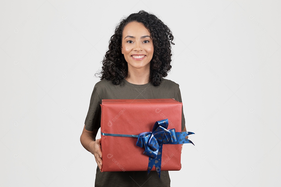 Linda mulher jovem cabelo cacheado sorridente segurando presente caixa sobre fundo branco