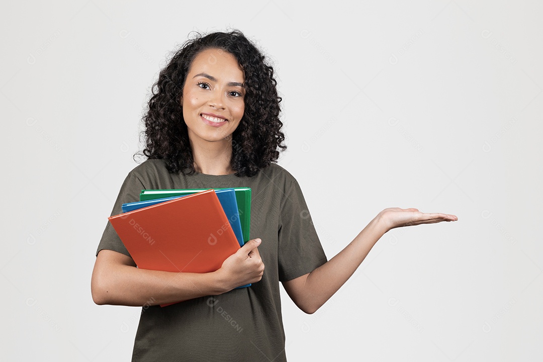 Linda mulher jovem cabelo cacheado estudante segurando materiais escolar cadernos sorridente sobre fundo branco