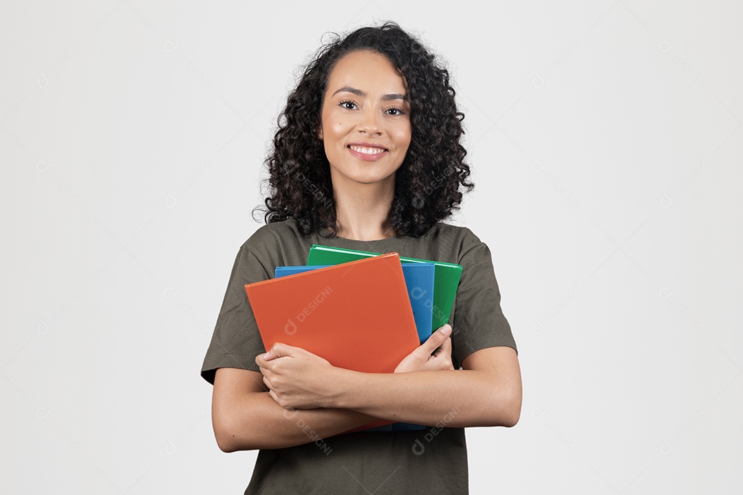Linda mulher jovem cabelo cacheado estudante segurando materiais escolar cadernos sorridente sobre fundo branco