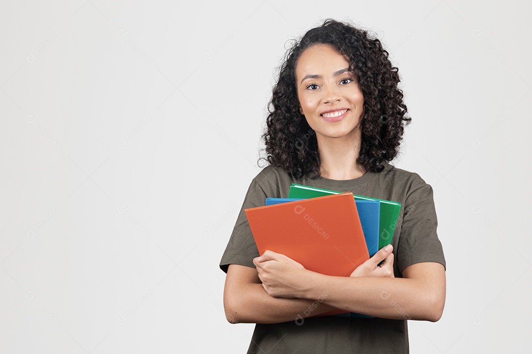 Linda mulher jovem cabelo cacheado estudante segurando materiais escolar cadernos sorridente sobre fundo branco
