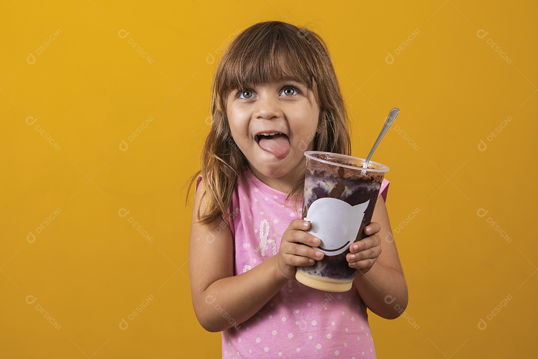 Linda criança segurando copo de açaí comida