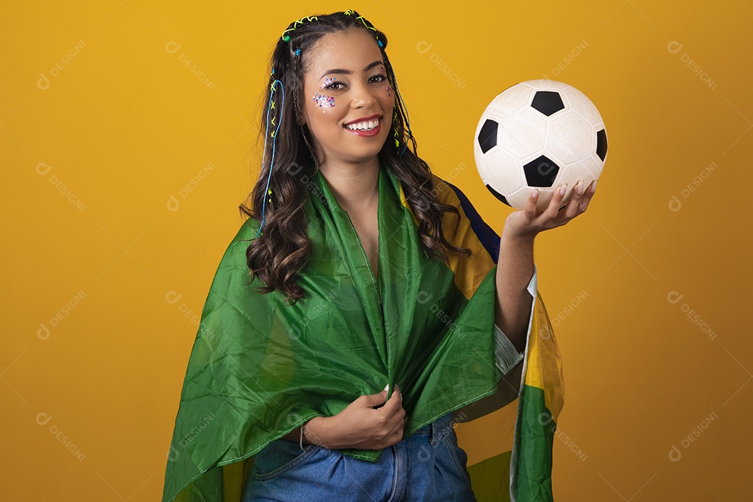 Linda mulher jovem com a bandeira do brasil nas suas costas sobre fundo amarelo