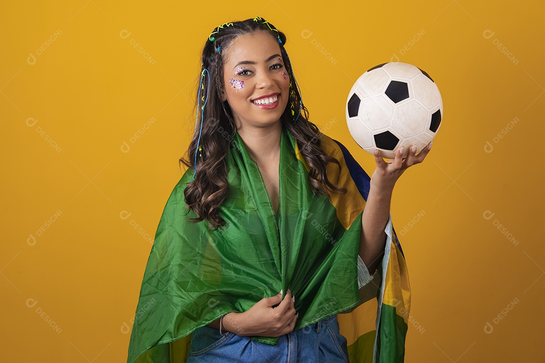 Linda mulher jovem com a bandeira do brasil nas suas costas sobre fundo amarelo