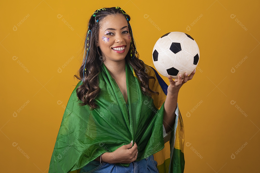 Linda mulher jovem com a bandeira do brasil nas suas costas sobre fundo amarelo