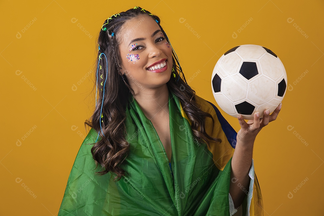 Linda mulher jovem com a bandeira do brasil nas suas costas sobre fundo amarelo