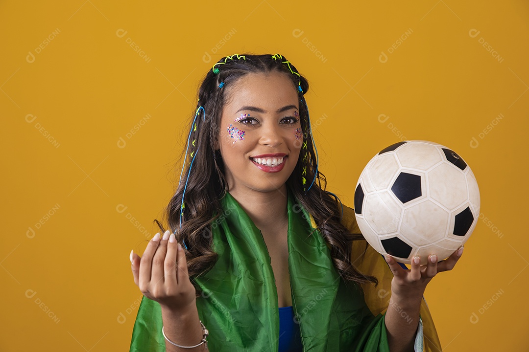 Linda mulher jovem com a bandeira do brasil nas suas costas sobre fundo amarelo