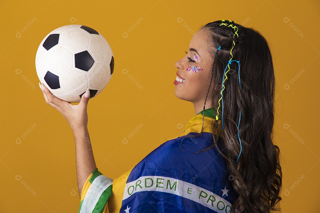 Linda mulher jovem com a bandeira do brasil nas suas costas sobre fundo amarelo