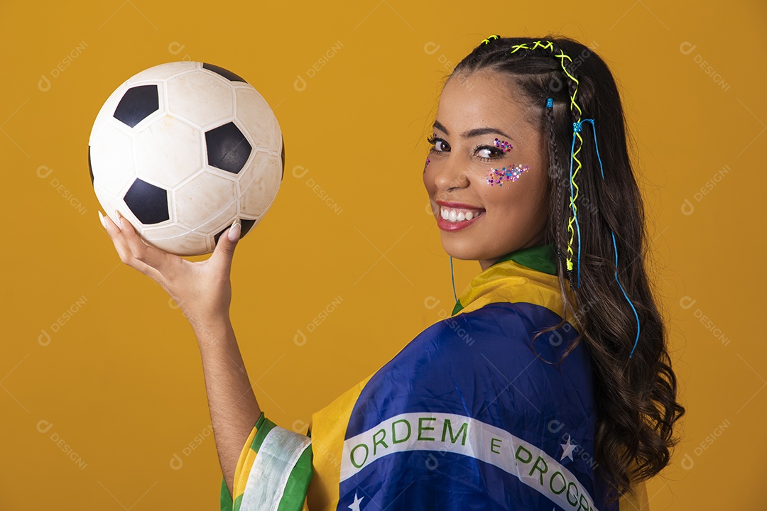 Linda mulher jovem com a bandeira do brasil nas suas costas sobre fundo amarelo