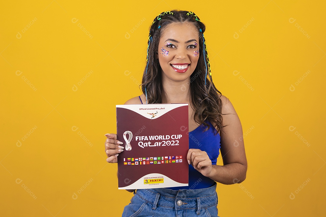 Linda mulher segurando álbum da copa do mundo 2022 sobre um fundo isolado amarelo