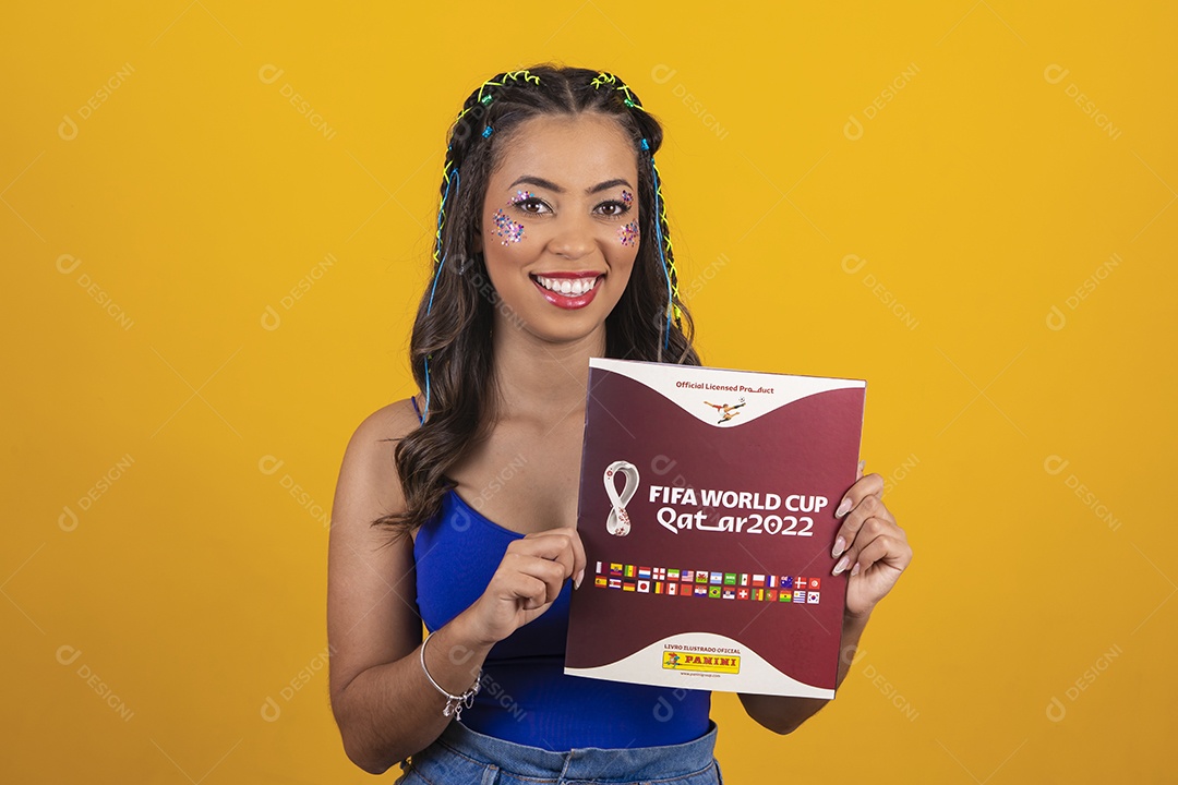 Linda mulher segurando álbum da copa do mundo 2022 sobre um fundo isolado amarelo