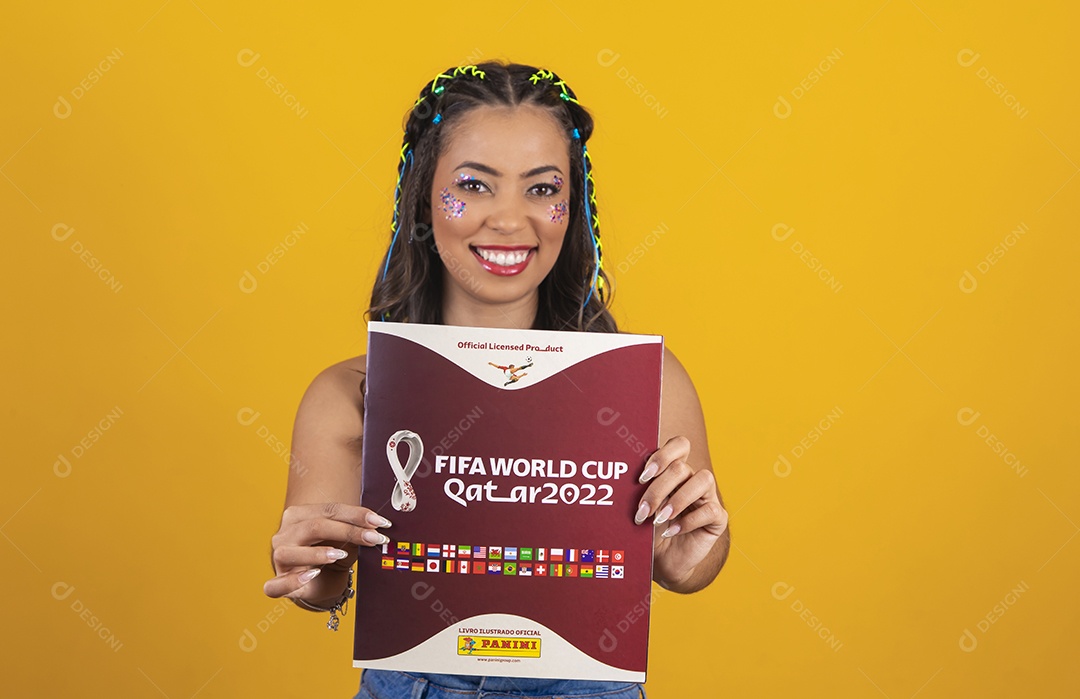 Linda mulher segurando álbum da copa do mundo 2022 sobre um fundo isolado amarelo