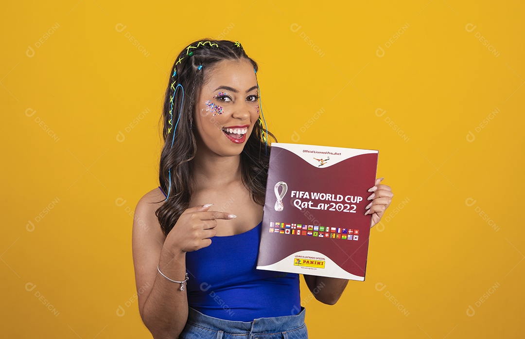 Linda mulher segurando álbum da copa do mundo 2022 sobre um fundo isolado amarelo