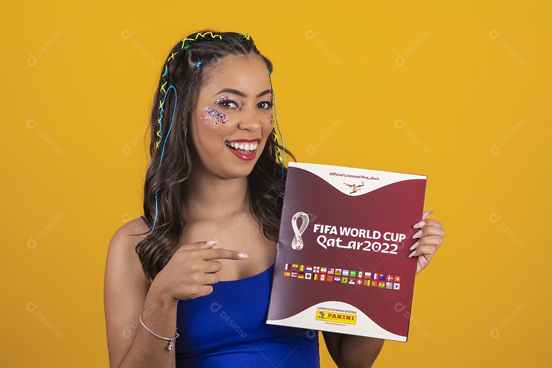 Linda mulher segurando álbum da copa do mundo 2022 sobre um fundo isolado amarelo