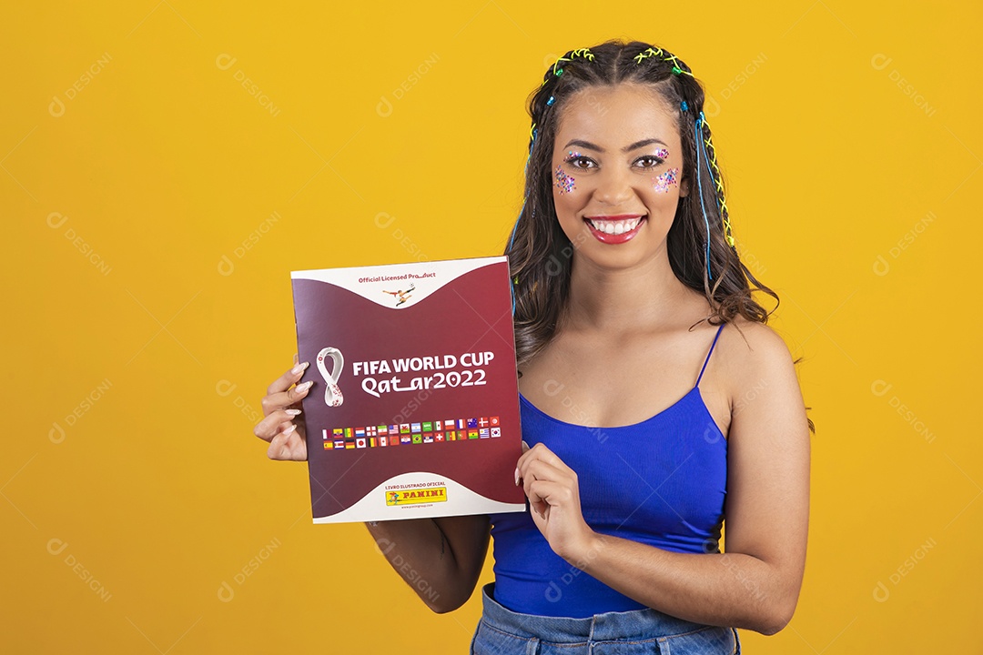 Linda mulher segurando álbum da copa do mundo 2022 sobre um fundo isolado amarelo