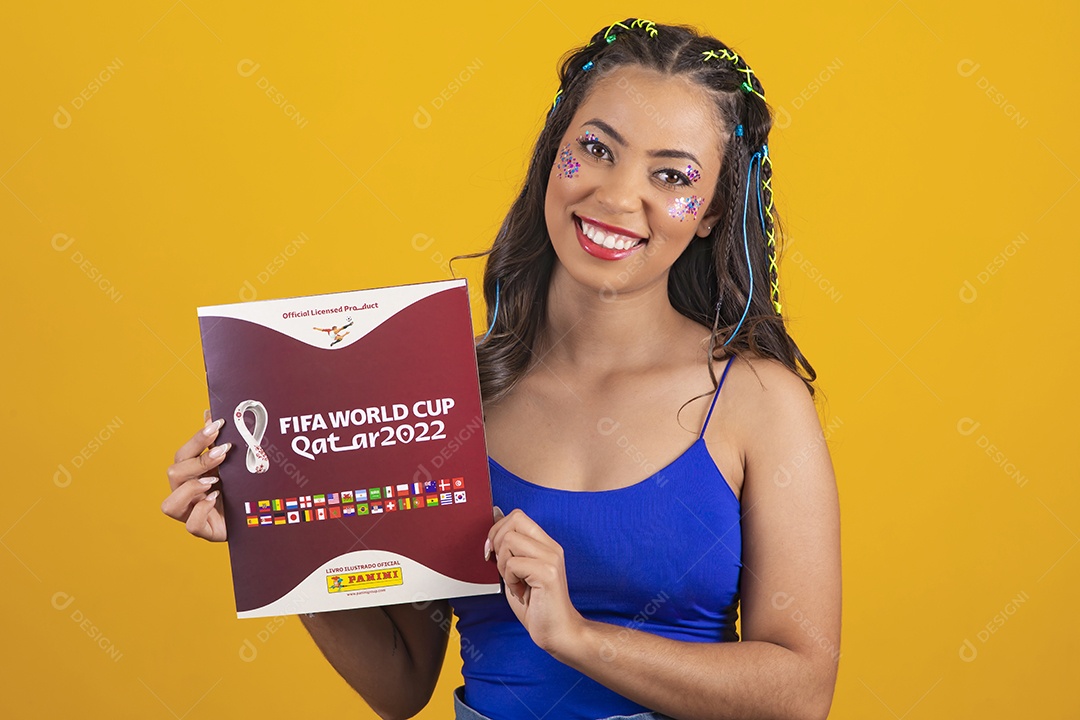 Linda mulher segurando álbum da copa do mundo 2022 sobre um fundo isolado amarelo