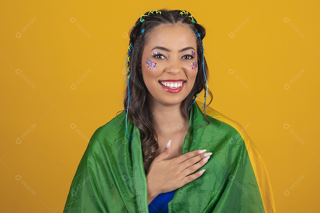 Linda mulher jovem com a bandeira do brasil nas suas costas sobre fundo amarelo