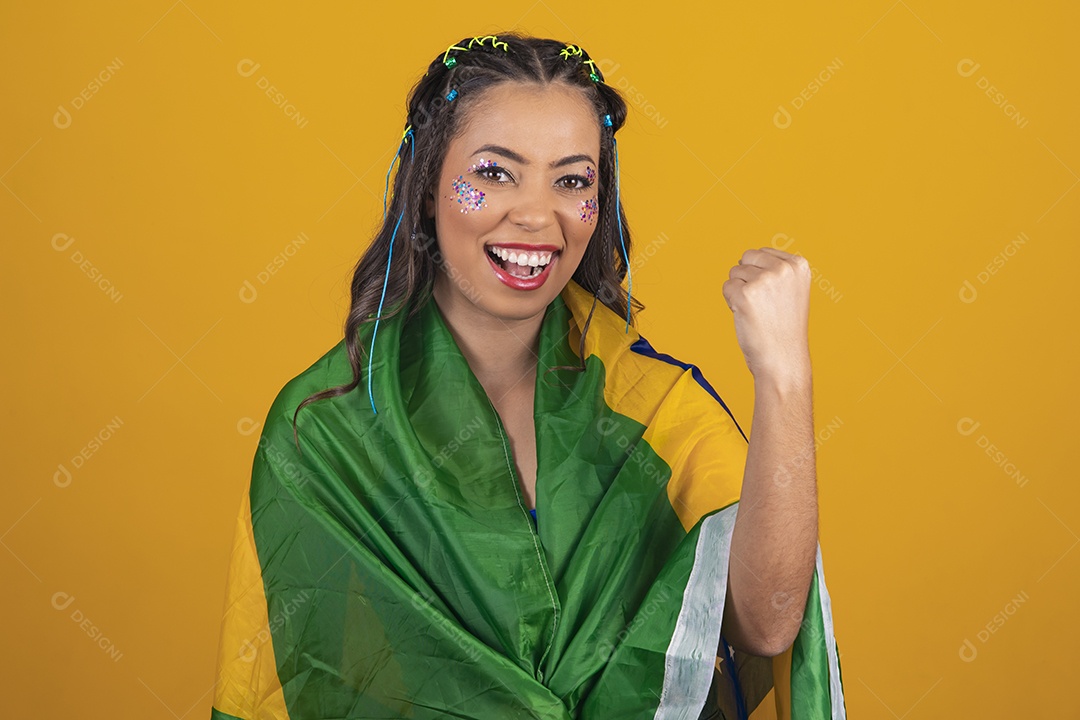 Linda mulher jovem com a bandeira do brasil nas suas costas sobre fundo amarelo