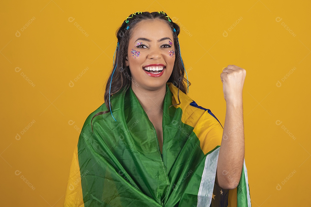 Linda mulher jovem com a bandeira do brasil nas suas costas sobre fundo amarelo
