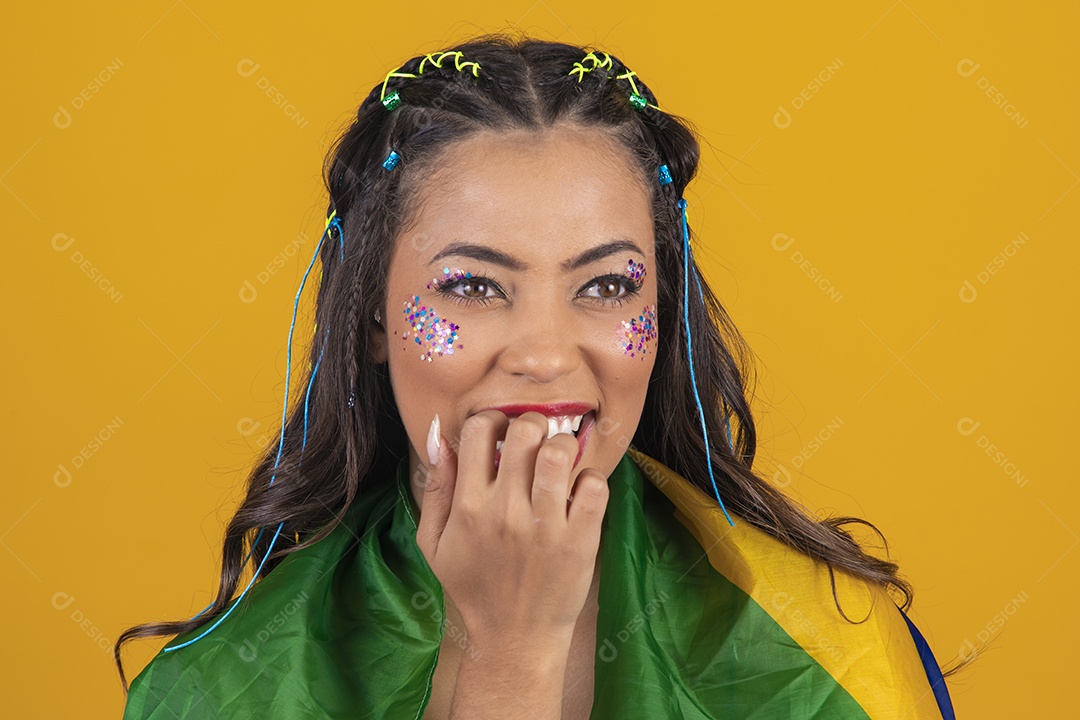 Linda mulher jovem com a bandeira do brasil nas suas costas sobre fundo amarelo