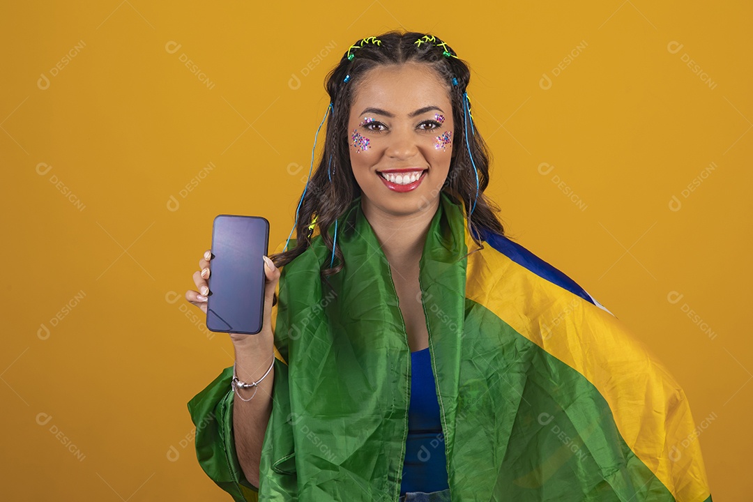 Linda mulher jovem com a bandeira do brasil nas suas costas sobre fundo amarelo