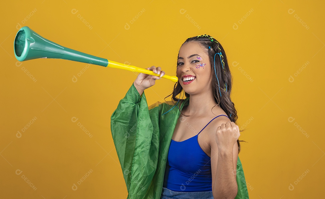 Linda mulher jovem com a bandeira do brasil nas suas costas sobre fundo amarelo