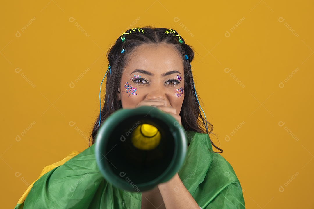 Linda mulher jovem com a bandeira do brasil nas suas costas sobre fundo amarelo