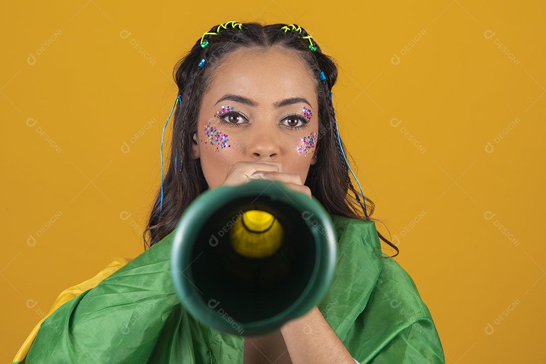 Linda mulher jovem com a bandeira do brasil nas suas costas sobre fundo amarelo