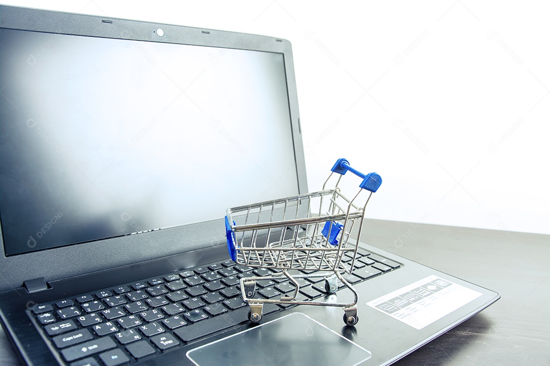 Tela em branco do notebook do computador com carrinho de compras na mesa de madeira