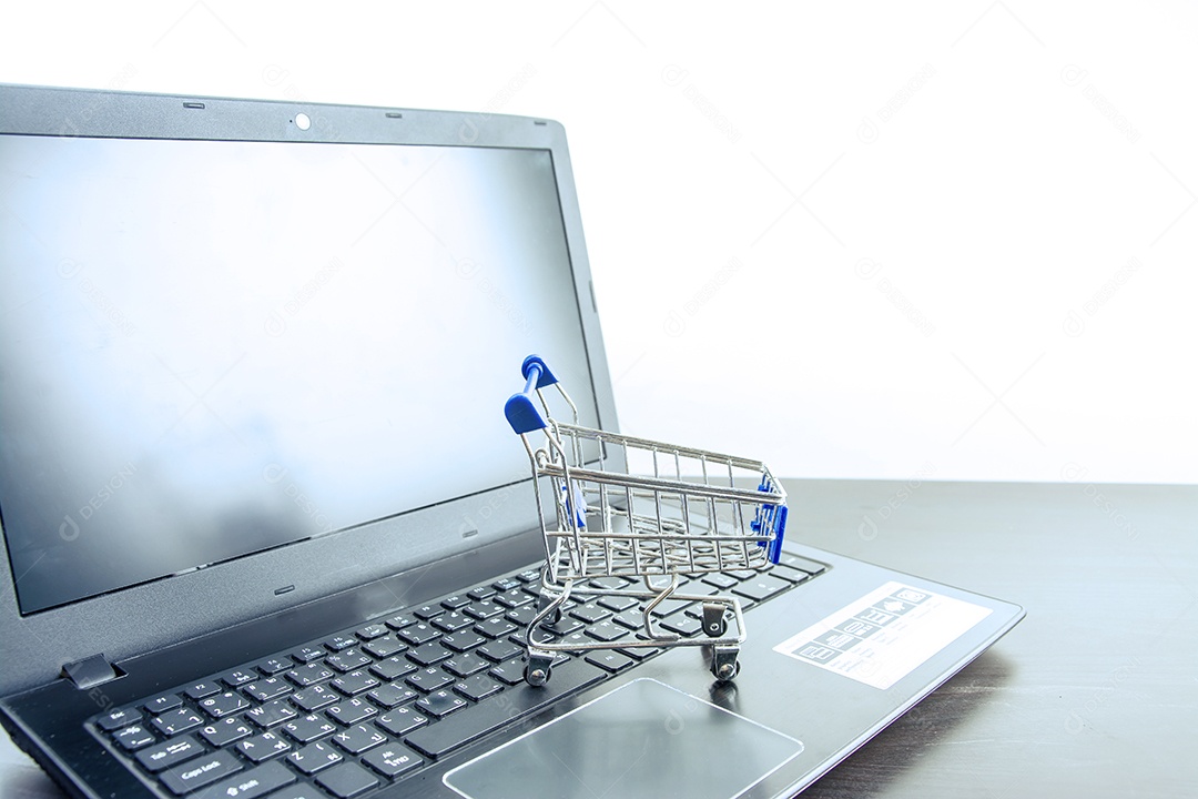 Tela em branco do notebook do computador com carrinho de compras na mesa de madeira