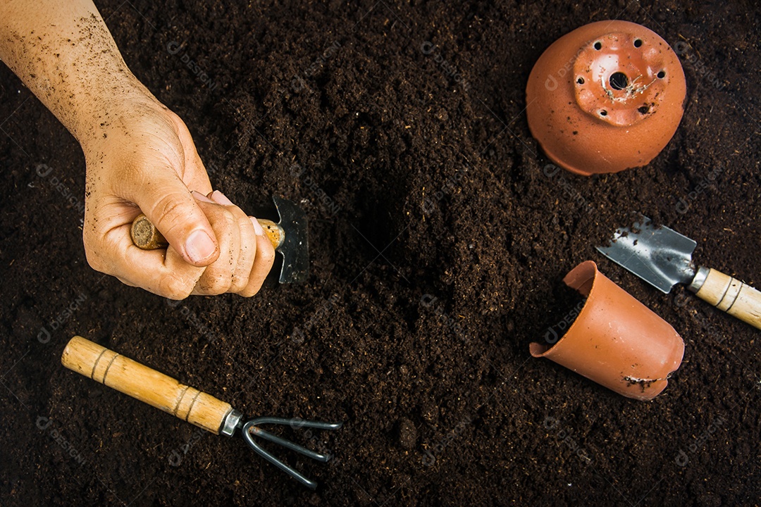 Equipamento de jardinagem e mão com solo