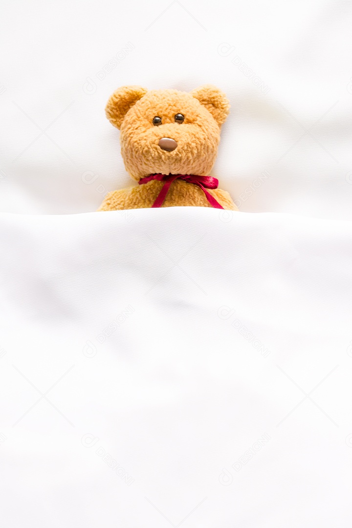 Boneca Teddy Bear deitada na cama branca
