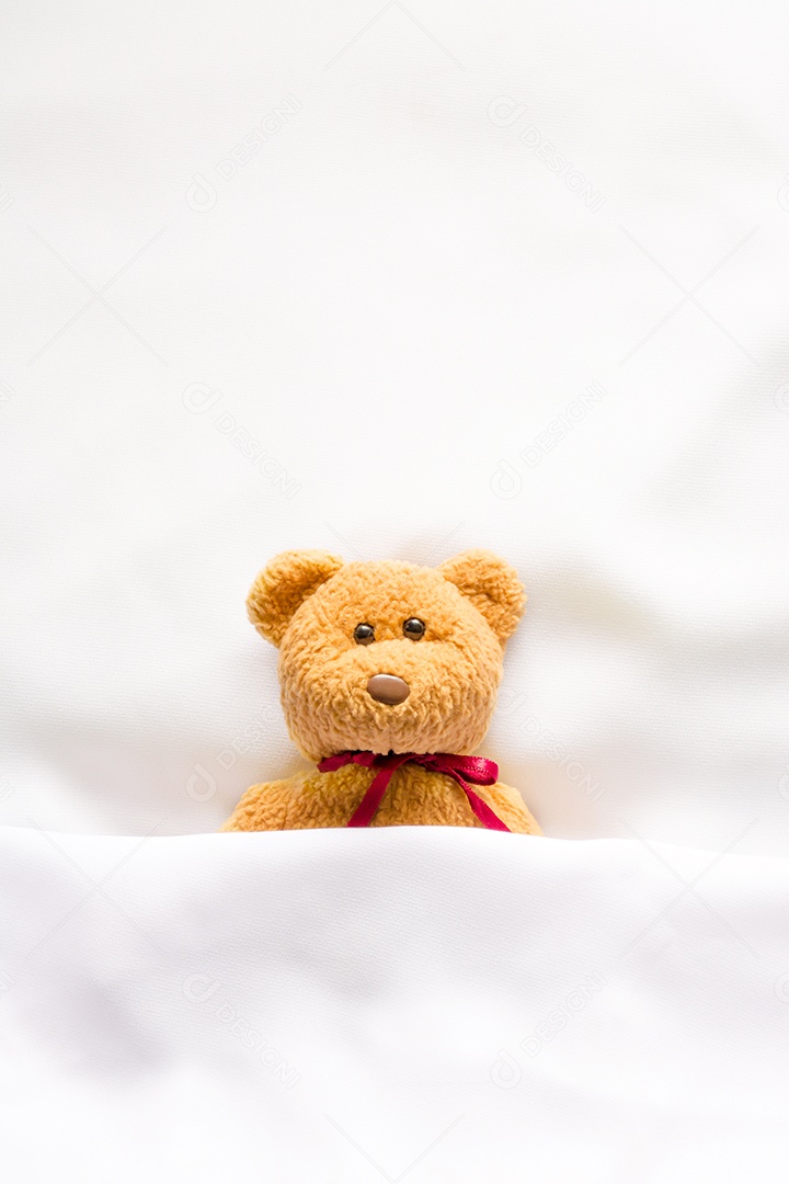 Boneca Teddy Bear deitada na cama branca