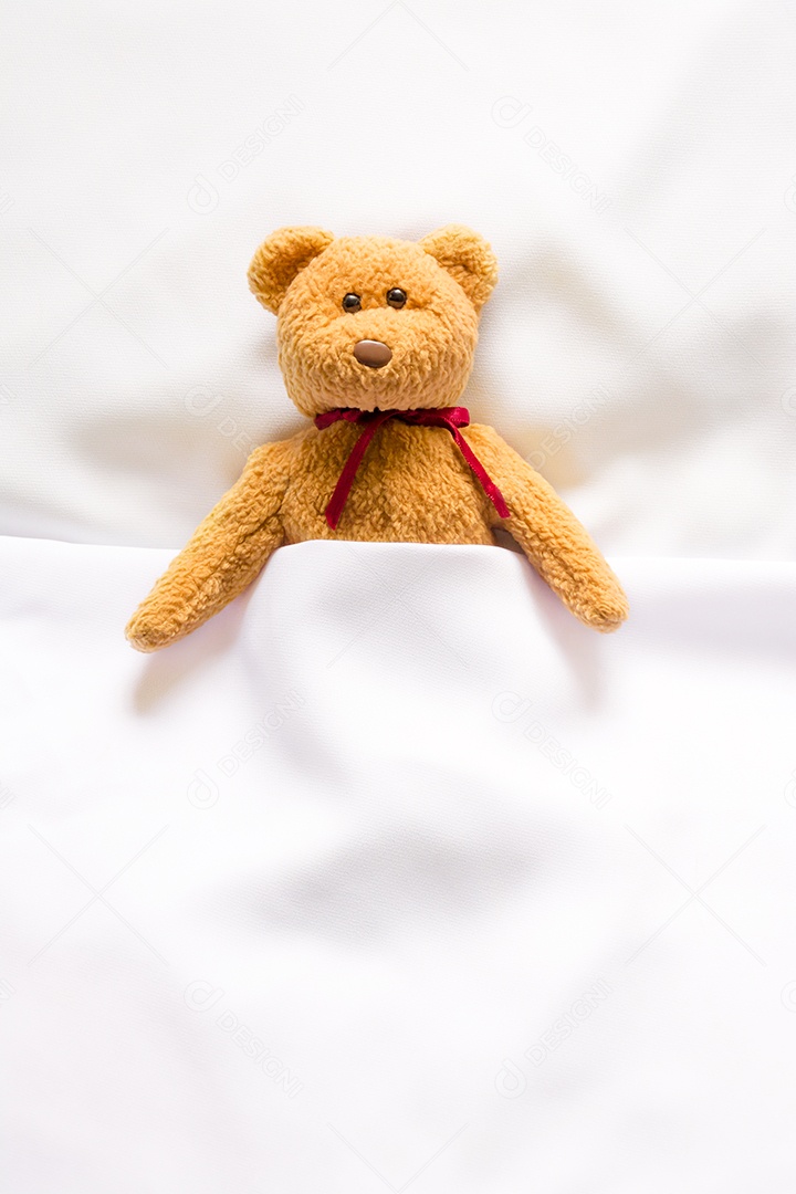 Boneca Teddy Bear deitada na cama branca
