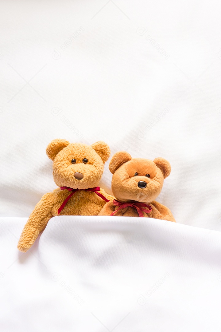 Boneca Teddy Bear deitada na cama branca