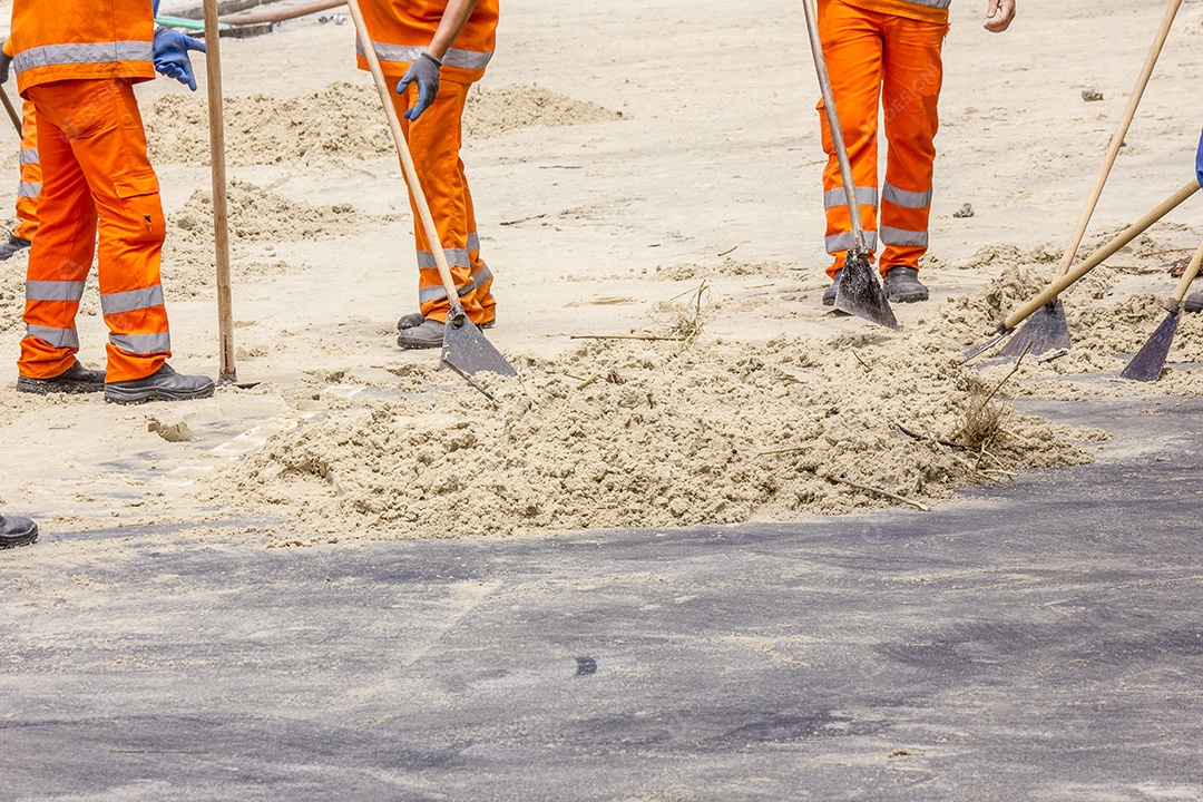 Men removing sand from the boardwalk after the surf.