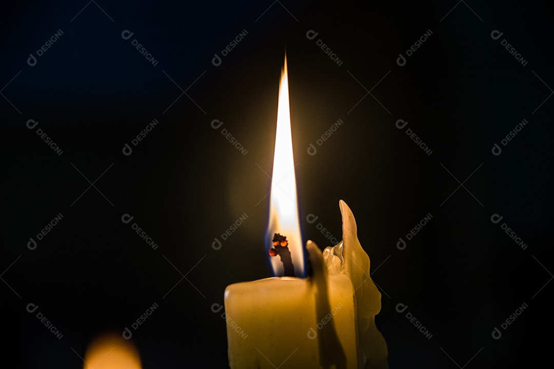 Luz de vela em fundo preto.